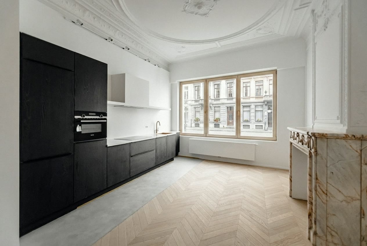 Zwarte keuken in herenhuis met ornamentplafond